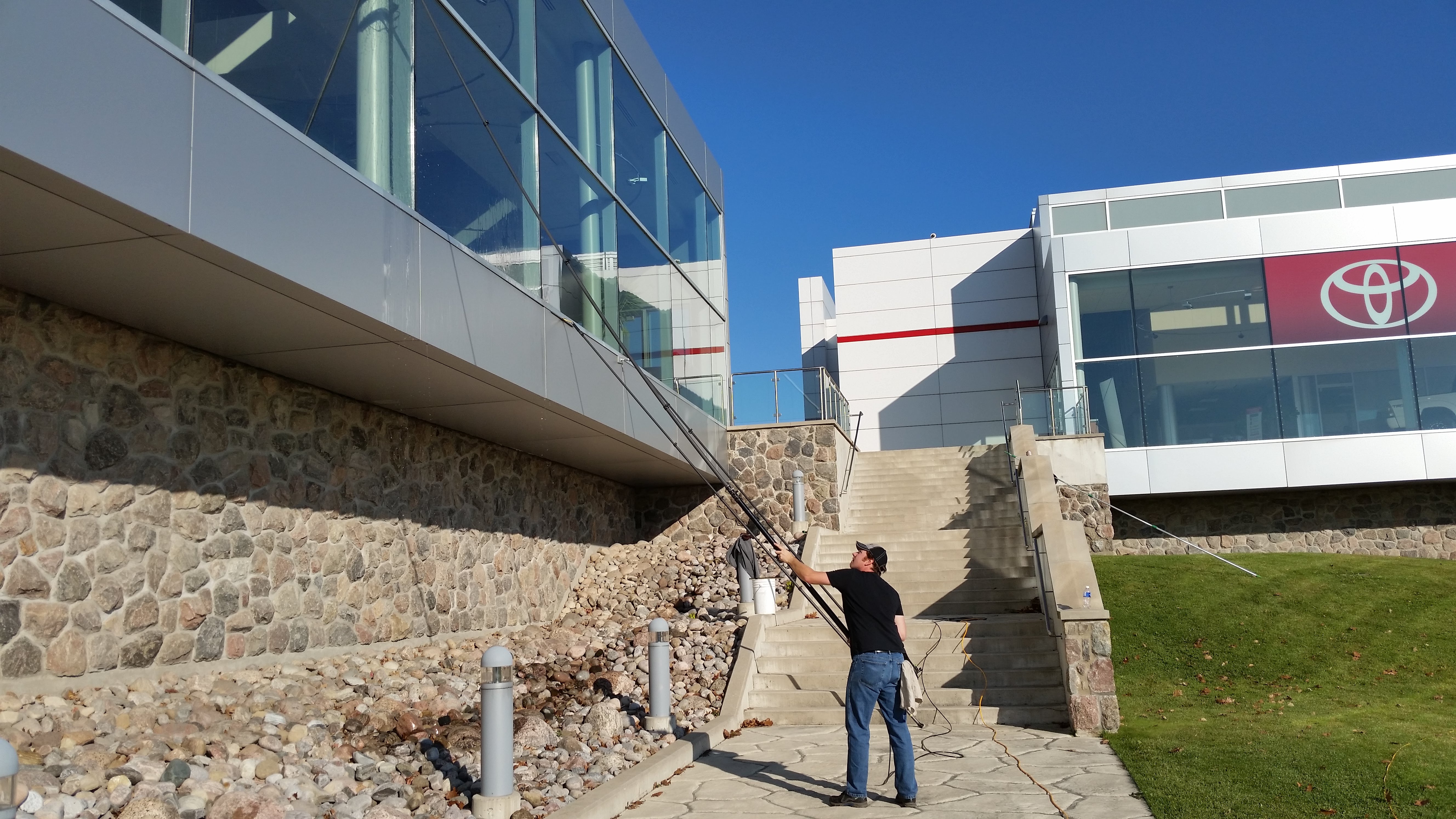 Commercial window cleaning at a car dealership